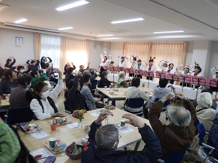 10人の演奏者が横一列に並び、両腕でMの形を作っています。会場の皆も両腕でMを作り、楽しんでいます。