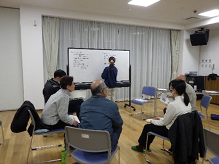 少数のグループで話し合いを行い、内1名がホワイトボードに意見をまとめています。
